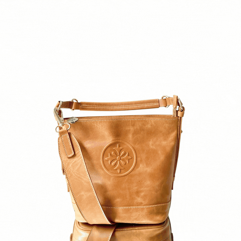 Cartera FILIPPA de cuero natural toffee (café claro) girando para mostrar el frente, el costado y el strap