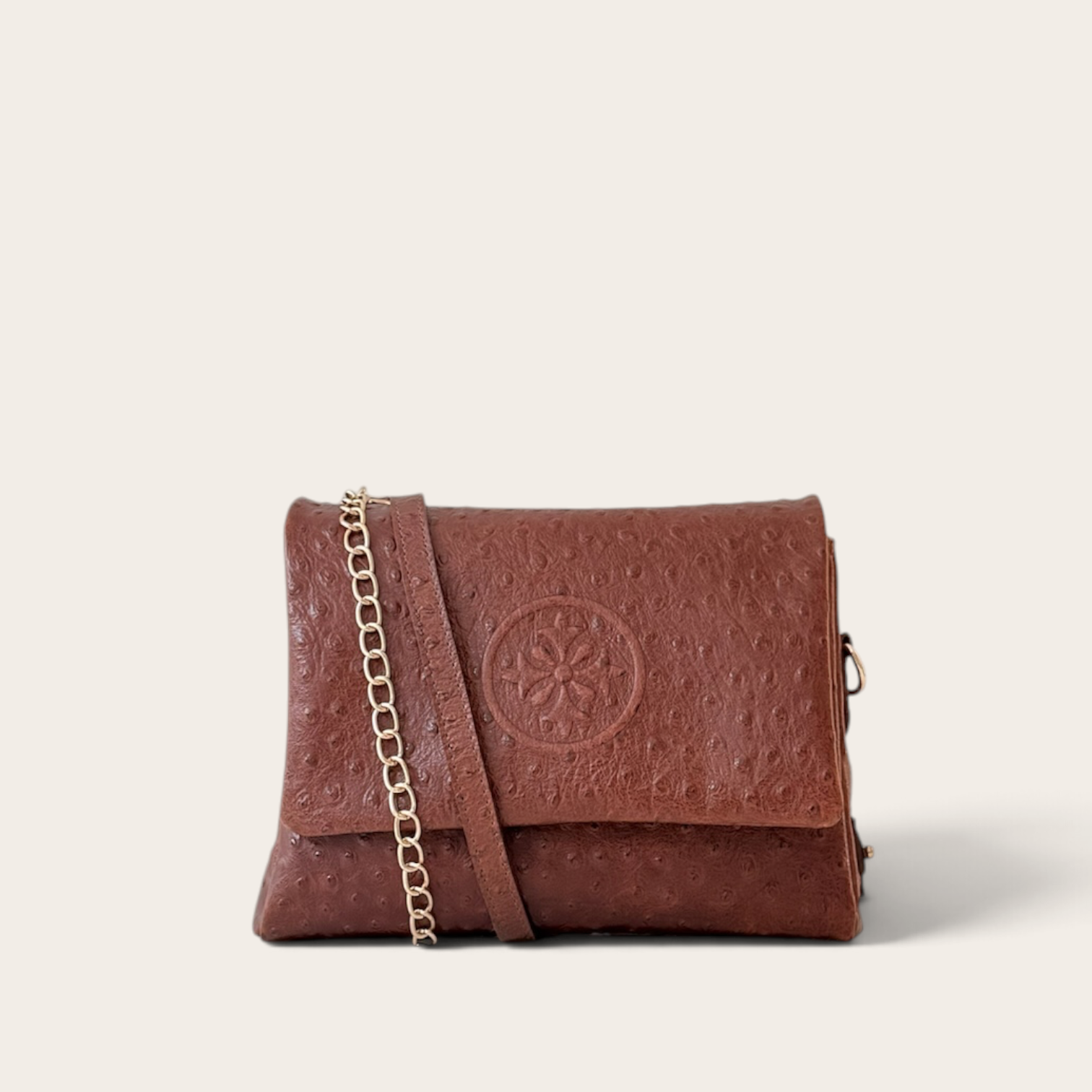 Cartera bandolera VITTORIA PETIT de cuero natural, textura lunares chocolate (café oscuro), vista frontal con cadena