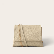 Cartera bandolera VITTORIA PETIT de cuero natural, textura lunares marfil (crema), vista frontal con cadena